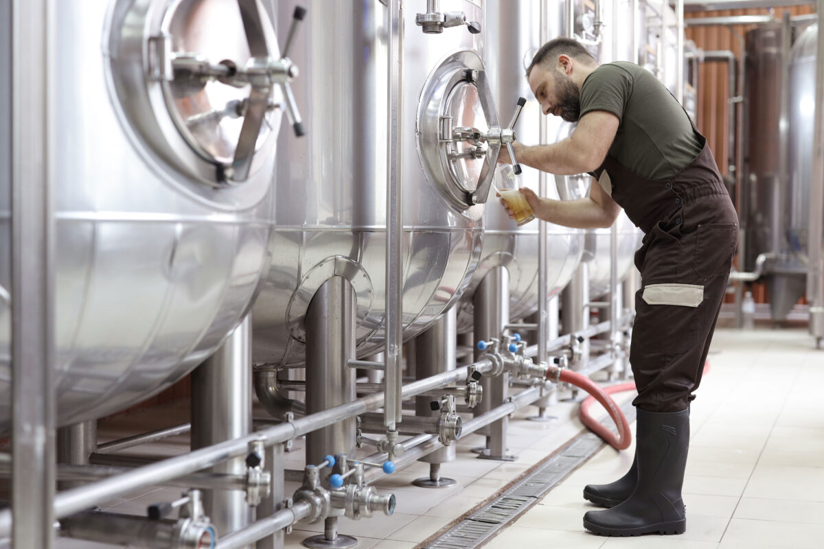 Brewery owner checking product covered with small business insurance in Davidson, NC