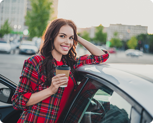 Woman smiling while leaning against car with auto insurance in Concord, NC